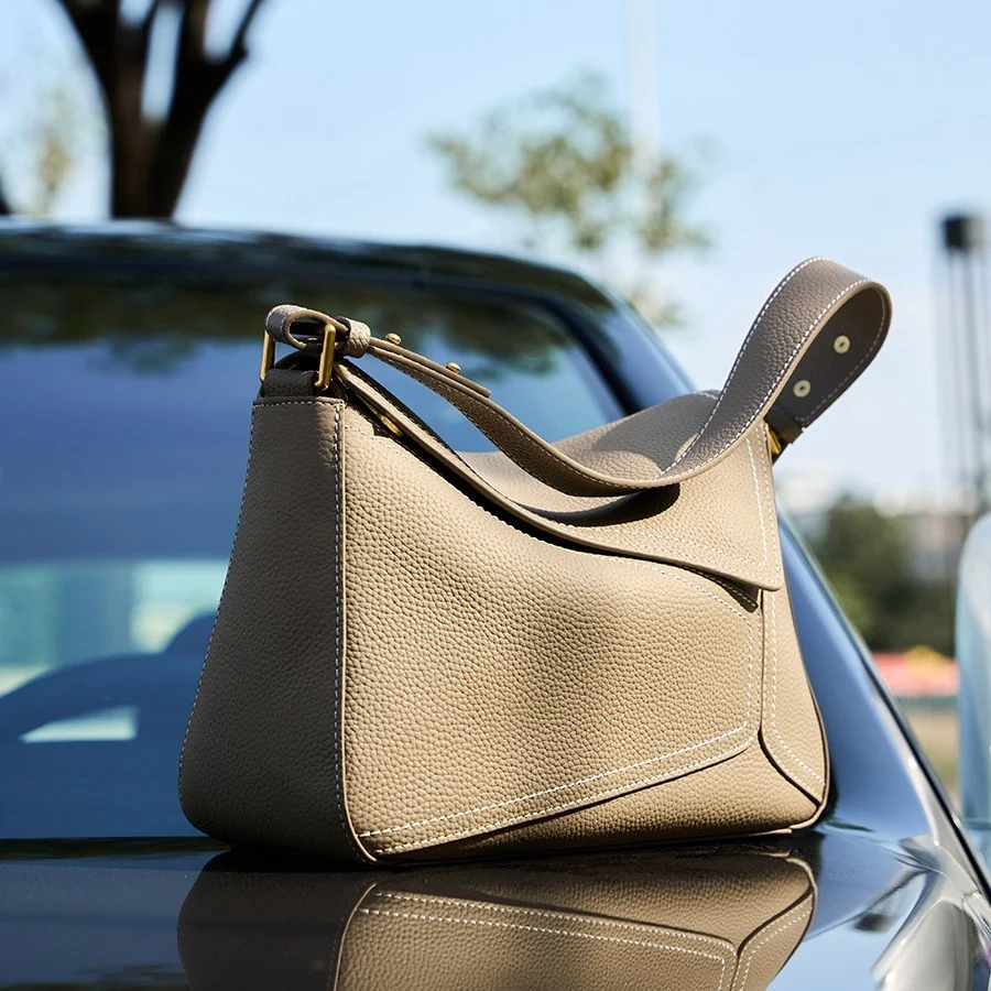 Sac cabas en cuir gris posé sur une chaise, élégance contemporaine