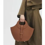 Femme portant le sac en cuir marron éléphant à l’épaule, démontrant le confort et le style décontracté du sac.