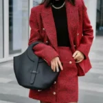 Femme habillée de façon élégante portant le sac en cuir noir, montrant comment il complète un look professionnel ou décontracté.