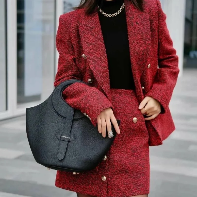 Femme habillée de façon élégante portant le sac en cuir noir, montrant comment il complète un look professionnel ou décontracté.