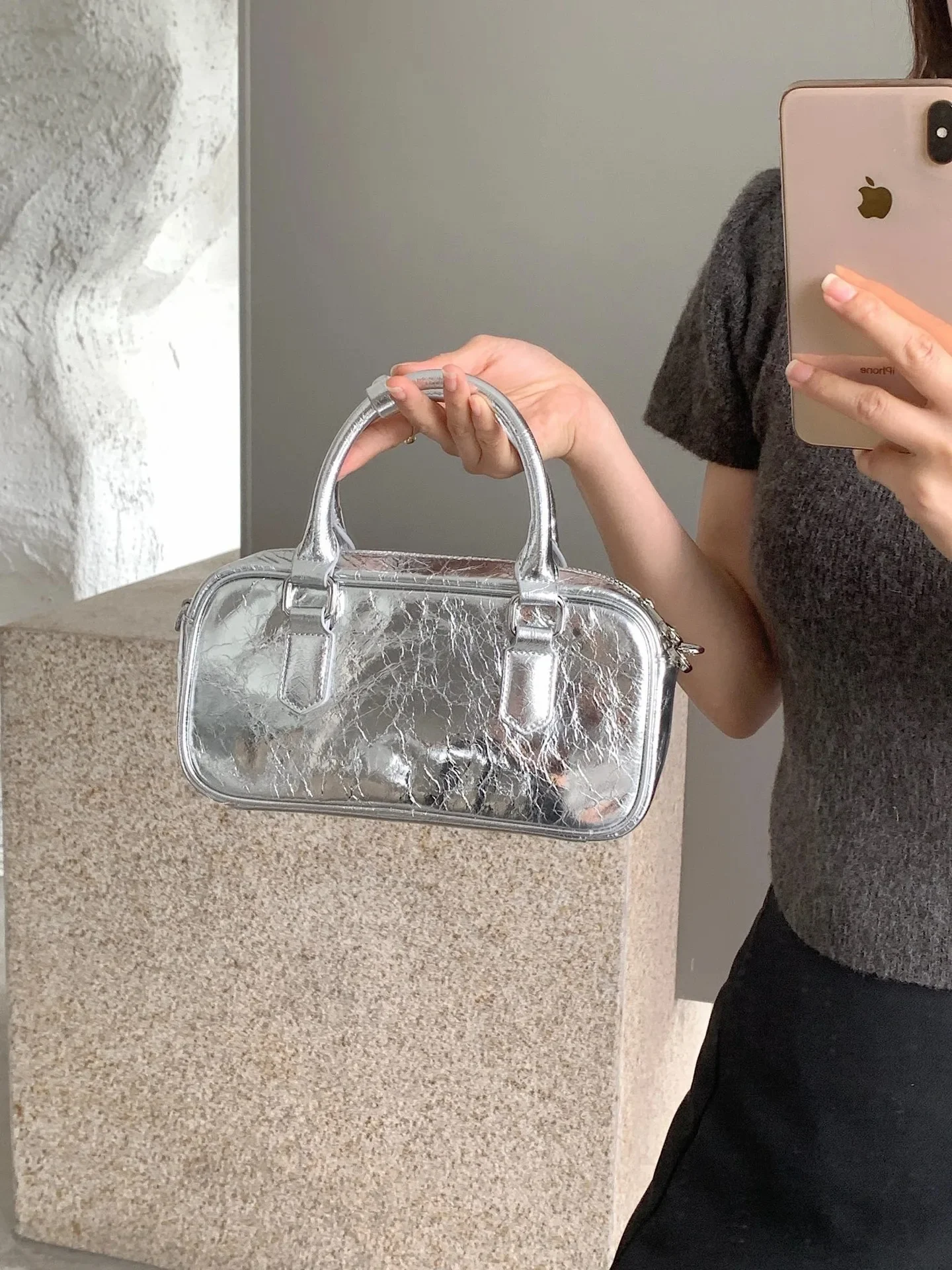 Design rétro et finition argentée brillante pour ce sac en cuir
