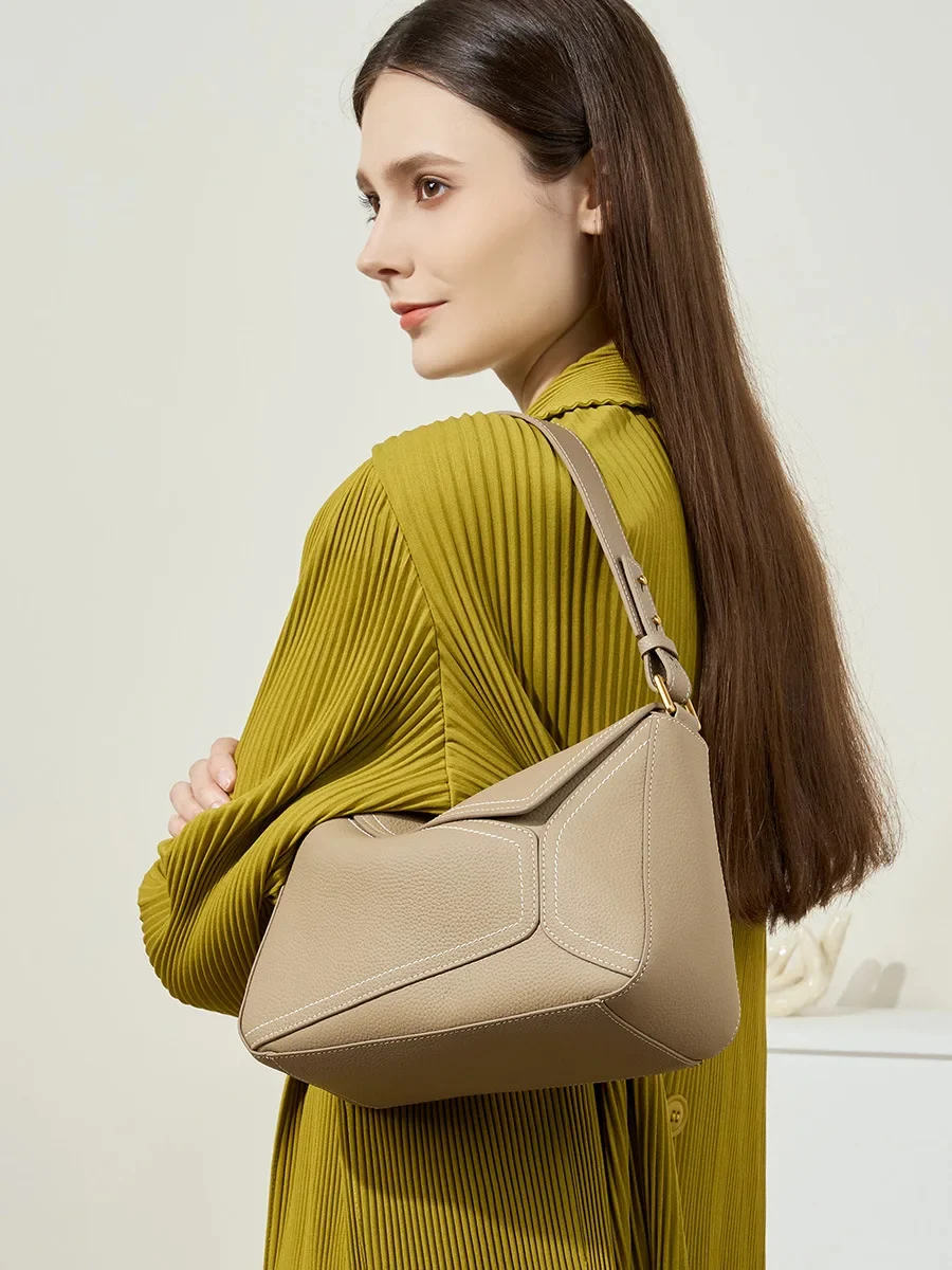 Sac cabas beige en cuir porté à l’épaule pour un look chic et urbain