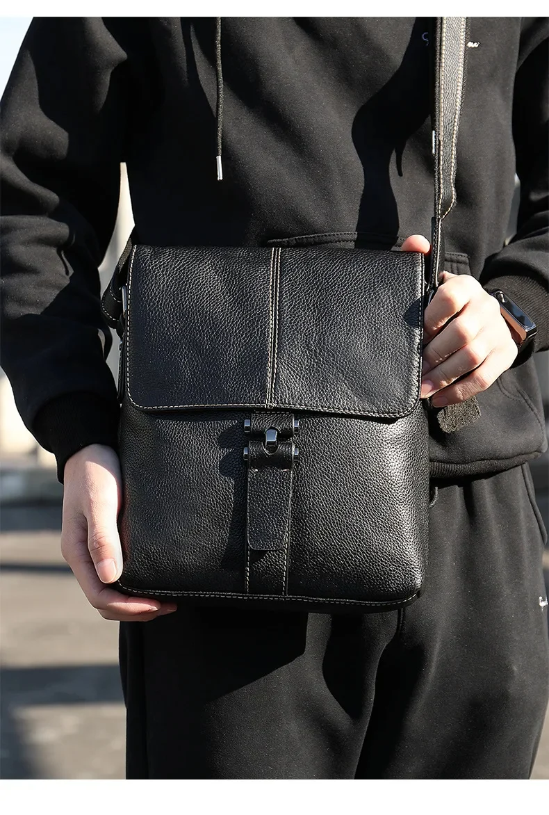 Sac à bandoulière en cuir noir avec bandoulière ajustable porté par un homme
