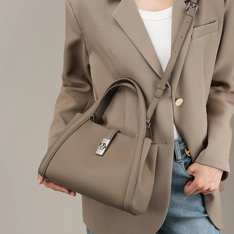 une femme porte notre Sac à main artisanal en cuir véritable gris